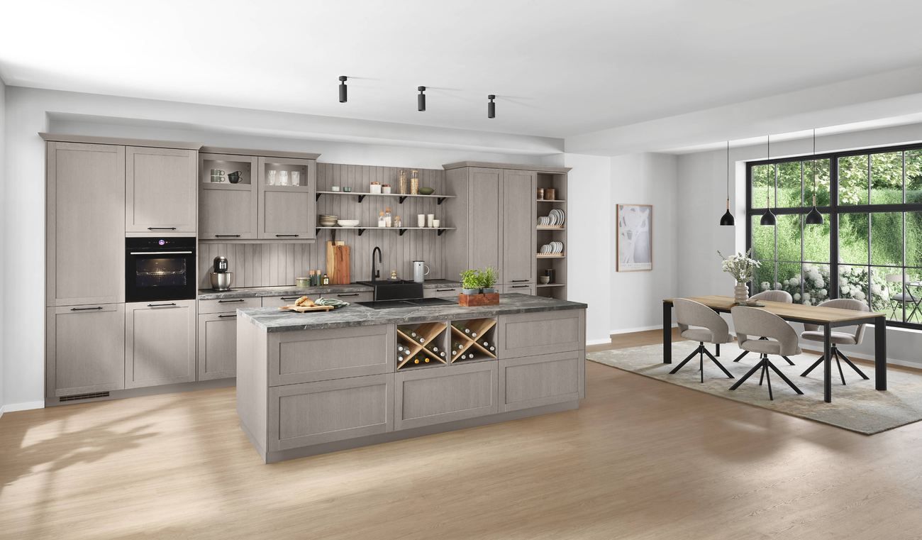 Cocina gris con isla y zona de comedor al fondo